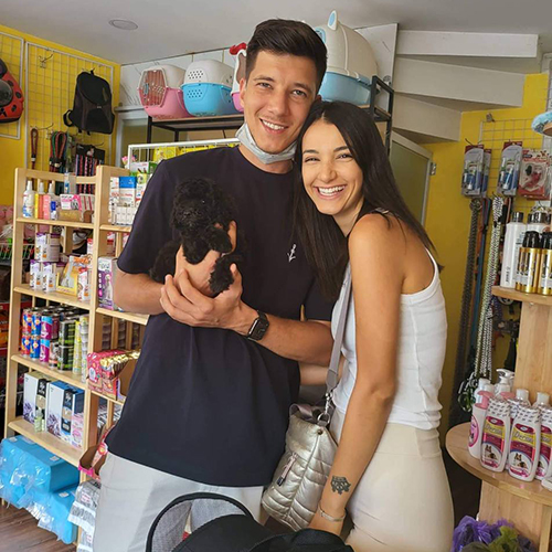 Cặp đôi nước ngoài bồng chó Poodle đen tại Chạm Pets Family, bé nhỏ gọn và nằm ngoan trong tay