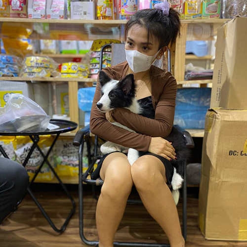 Khách ôm chó Border Collie đen trắng khi nhận bàn giao tại shop Chạm Pets Family