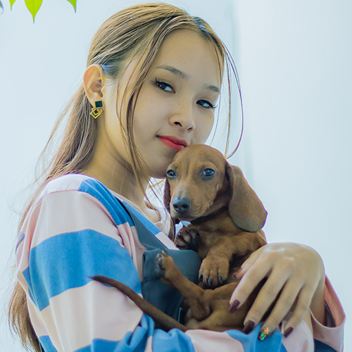 Khách hàng ôm chó Lạp Xưởng màu nâu đỏ, ảnh bàn giao tại Chạm Pets