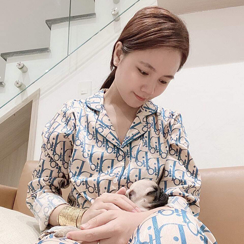 Người bế chó Pug con trong lòng, khoảnh khắc ôm ấp nhẹ nhàng trong nhà