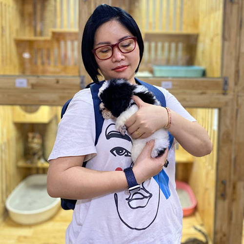 Khách hàng bế chó Poodle bò sữa đen trắng khi xem bé thực tế