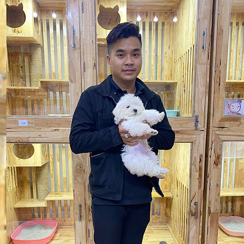 Khách hàng bế chó Poodle trắng khi chọn size phù hợp