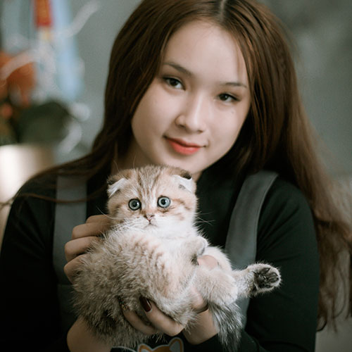 Người phụ nữ ôm mèo tai cụp golden con