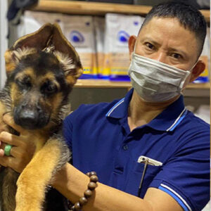 Khách bế bé chó Becgie Đức màu đen vàng tại Chạm Pets Family trong ngày bàn giao