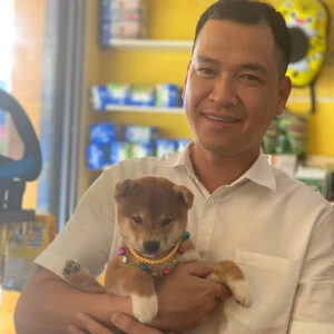 Khách nam bế bé chó Shiba vàng đỏ tại Chạm Pets Family trong ngày bàn giao