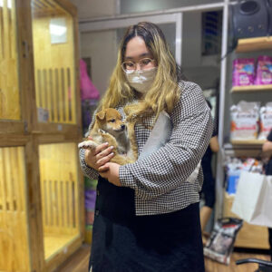 Khách nữ bế bé chó Shiba vàng đỏ tại Chạm Pets Family trong ngày nhận bé